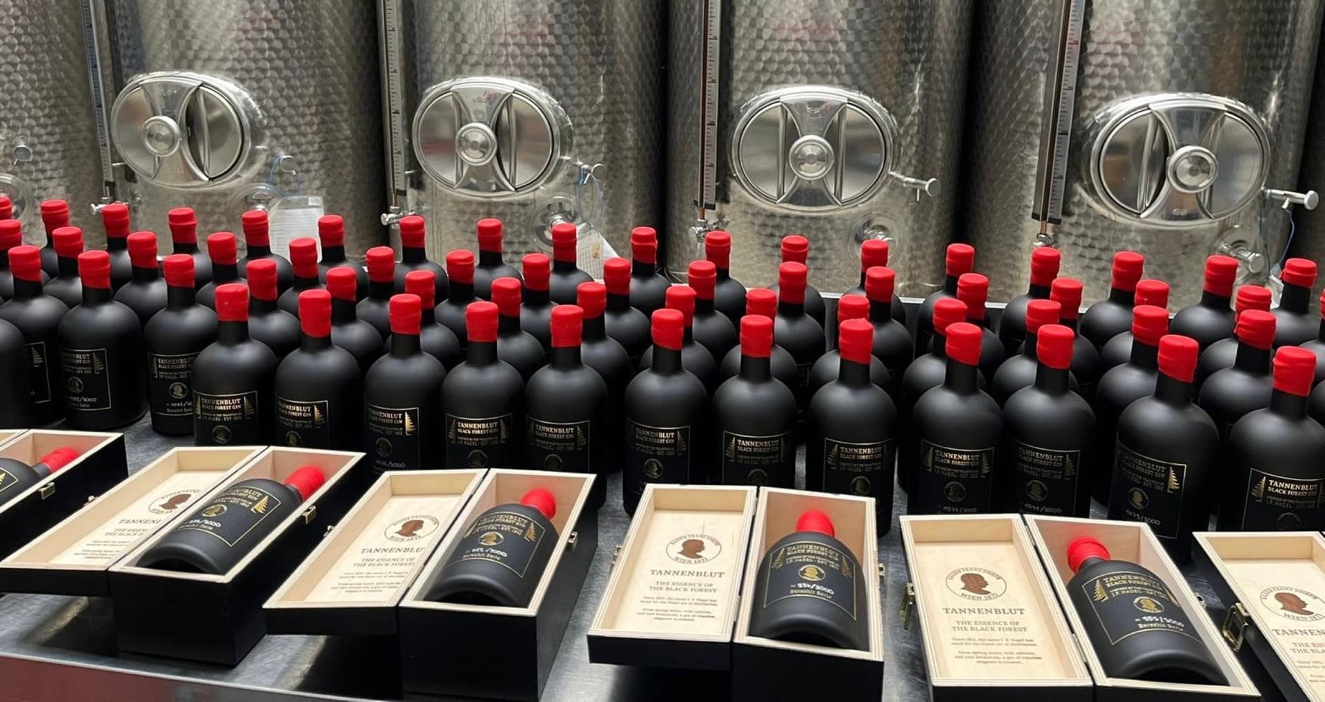 Tannenblut Bereshit Series bottling — stainless fermenters, hand-numbered bottles with red wax seals, fir-wood presentation boxes